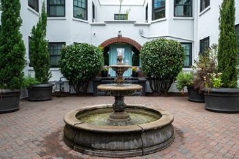 a fountain in a courtyard in front of a building
